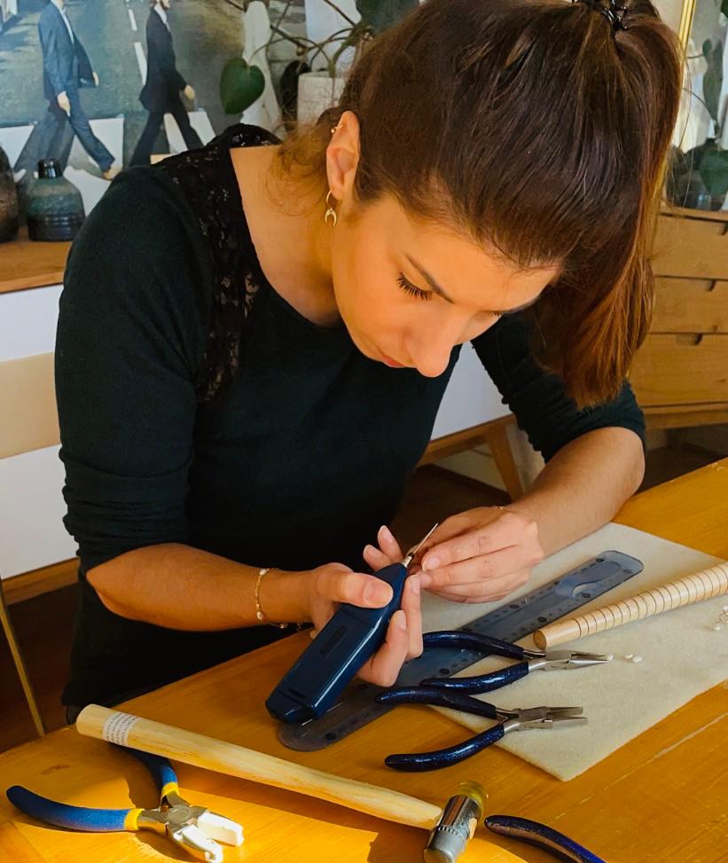 Une fille entrain de fabriquer un bijou avec ses outils à coté d'elle
